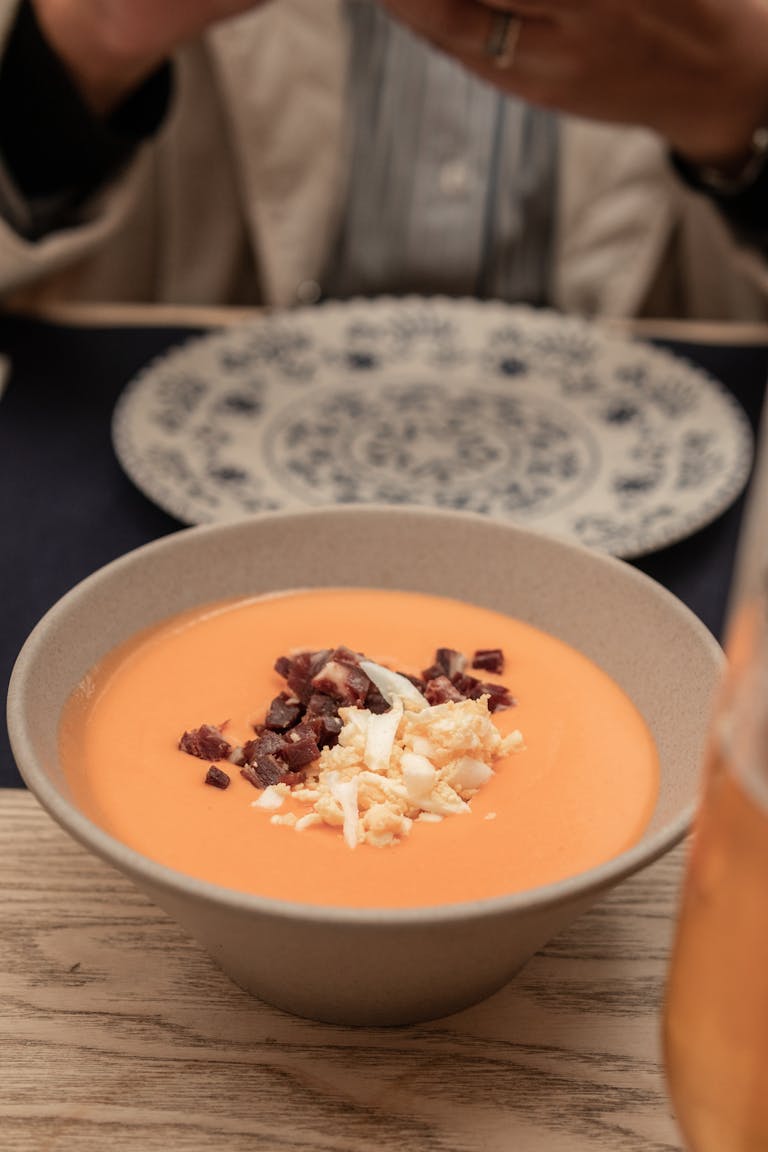 Delicious salmorejo served in a ceramic bowl, topped with ham and egg, perfect for traditional Spanish cuisine lovers.